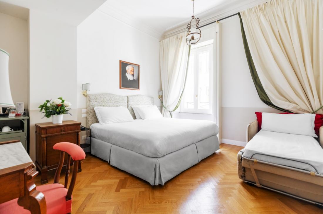 Camera luminosa, elegante, con letto matrimoniale e letto singolo, atmosfera accogliente.