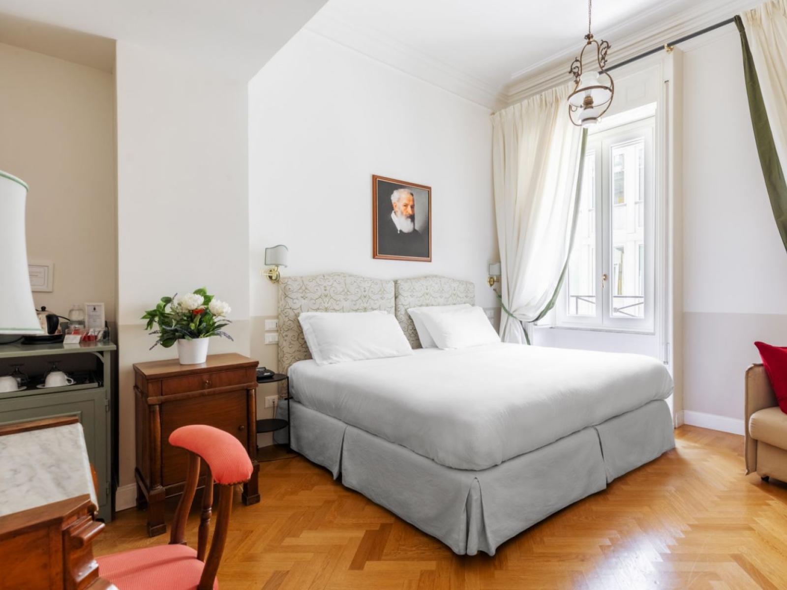 Camera luminosa, elegante, con letto accogliente e dettagli raffinati.