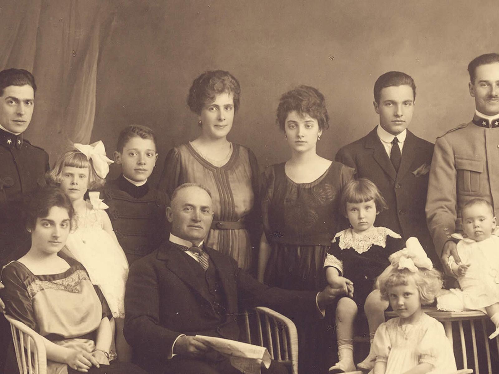 Una famiglia numerosa in posa, elegante e solenne, in una foto d'epoca.