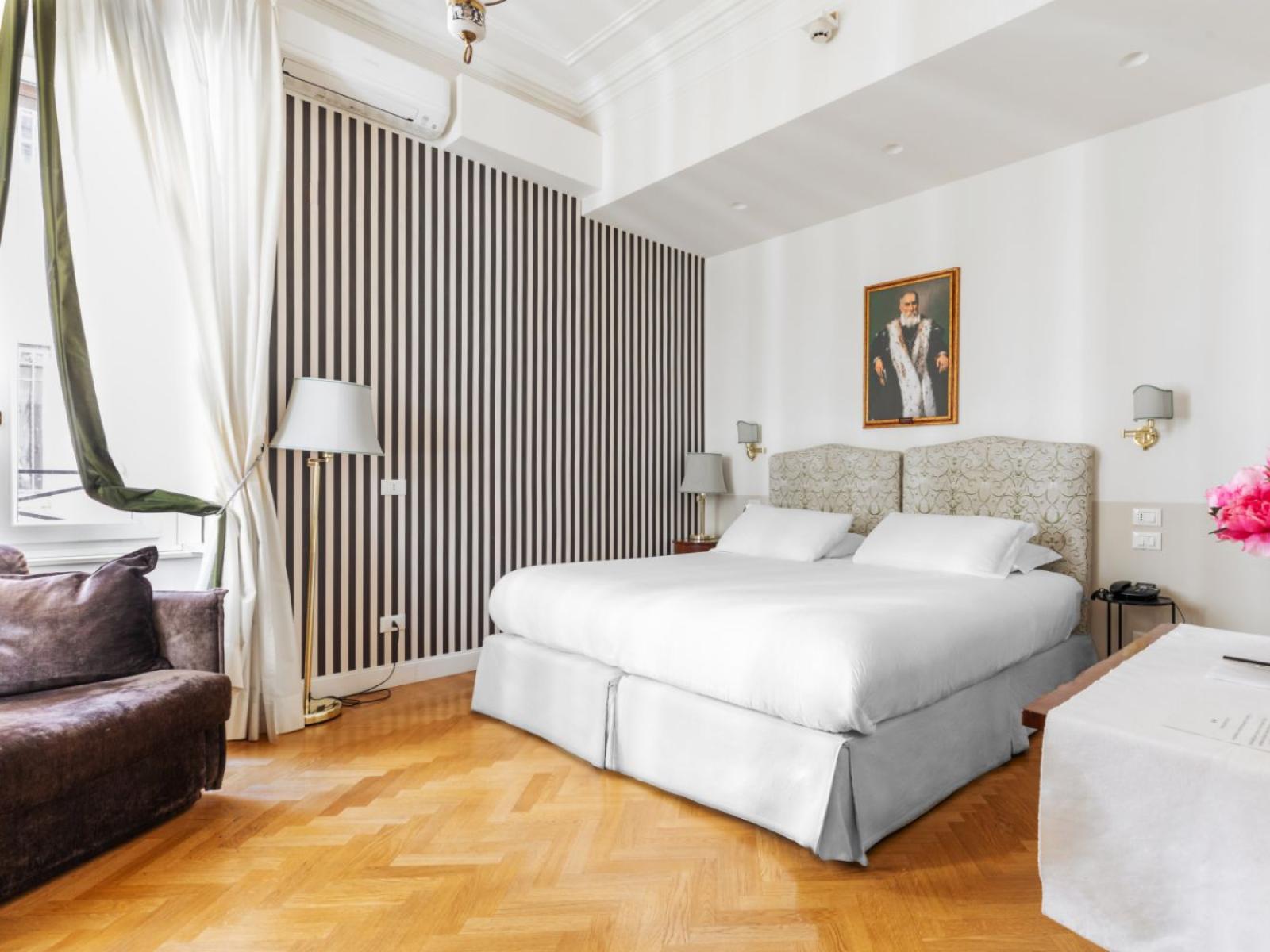 Camera elegante con letto soffice, parquet e fiori vivaci.
