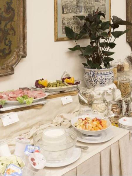 Elegante buffet con affettati, frutta e dolci in un'atmosfera classica e raffinata.