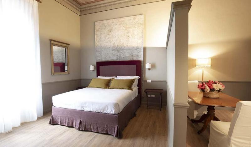 Camera elegante e luminosa, con letto accogliente e arredi raffinati.