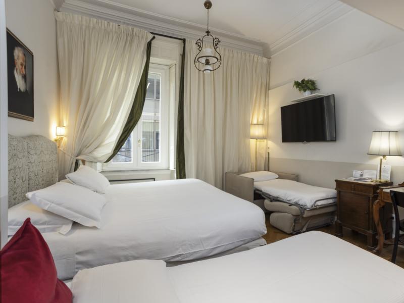 Camera accogliente con letti bianchi, arredi eleganti, atmosfera calda e rilassante.