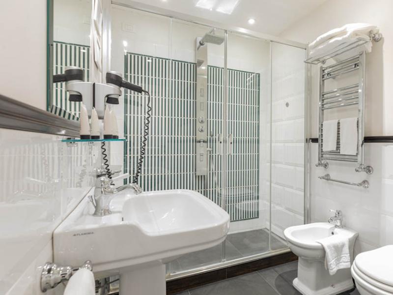 Bagno elegante e luminoso con doccia moderna e accessori raffinati.