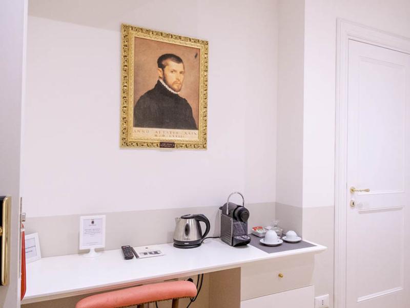 Interno elegante con ritratto antico e angolo caffè raffinato.